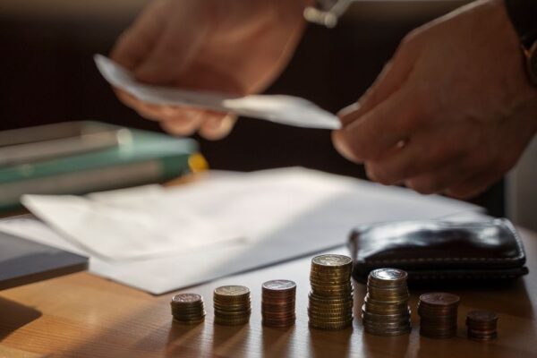 Picture of a person with papers and coins on the table.