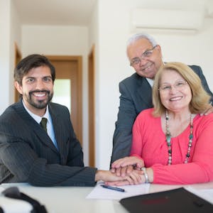 Smiling senior couple meeting with a professional advisor in a bright indoor setting.